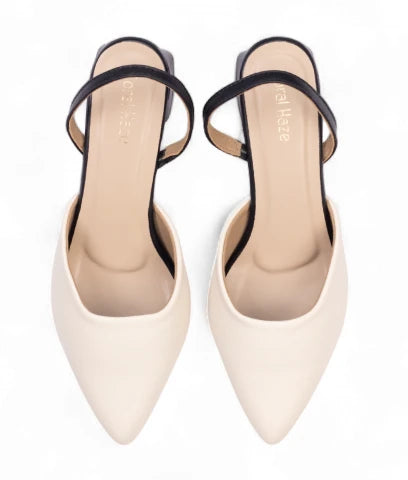 Pair of white pointed-toe high heels for women by Coral Haze with thin black straps.